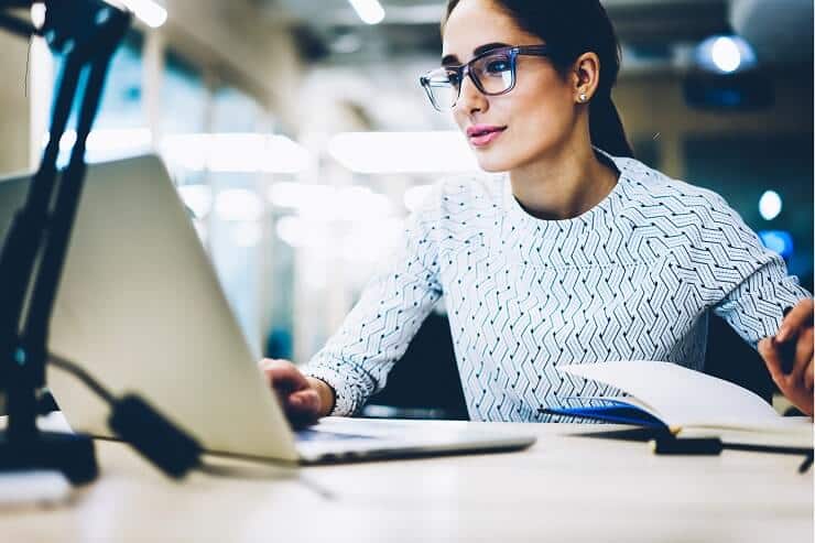 Frau arbeitet konzentriert am Laptop in einem modernen Büro