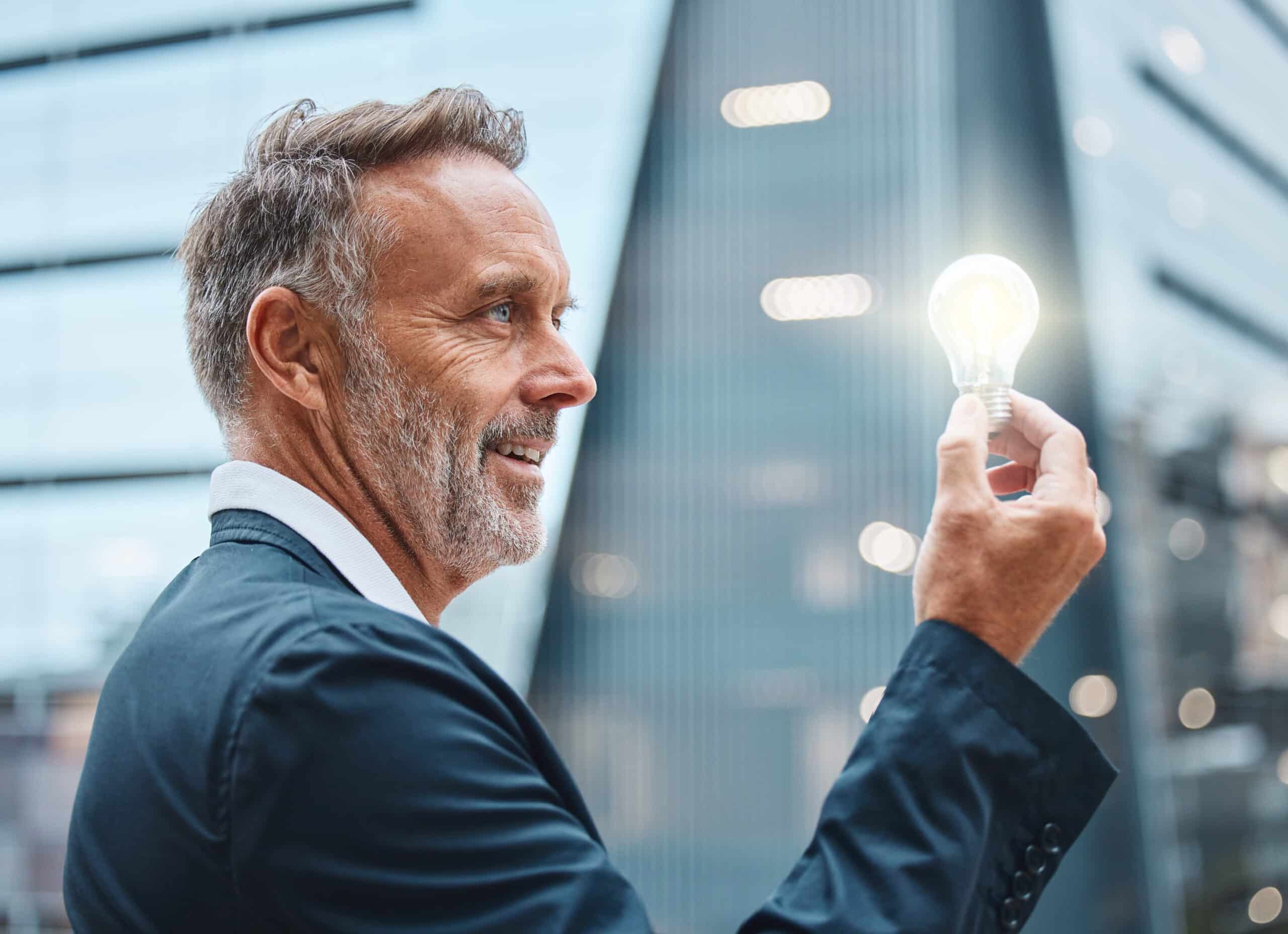Person hält eine leuchtende Glühbirne als Symbol für Innovation