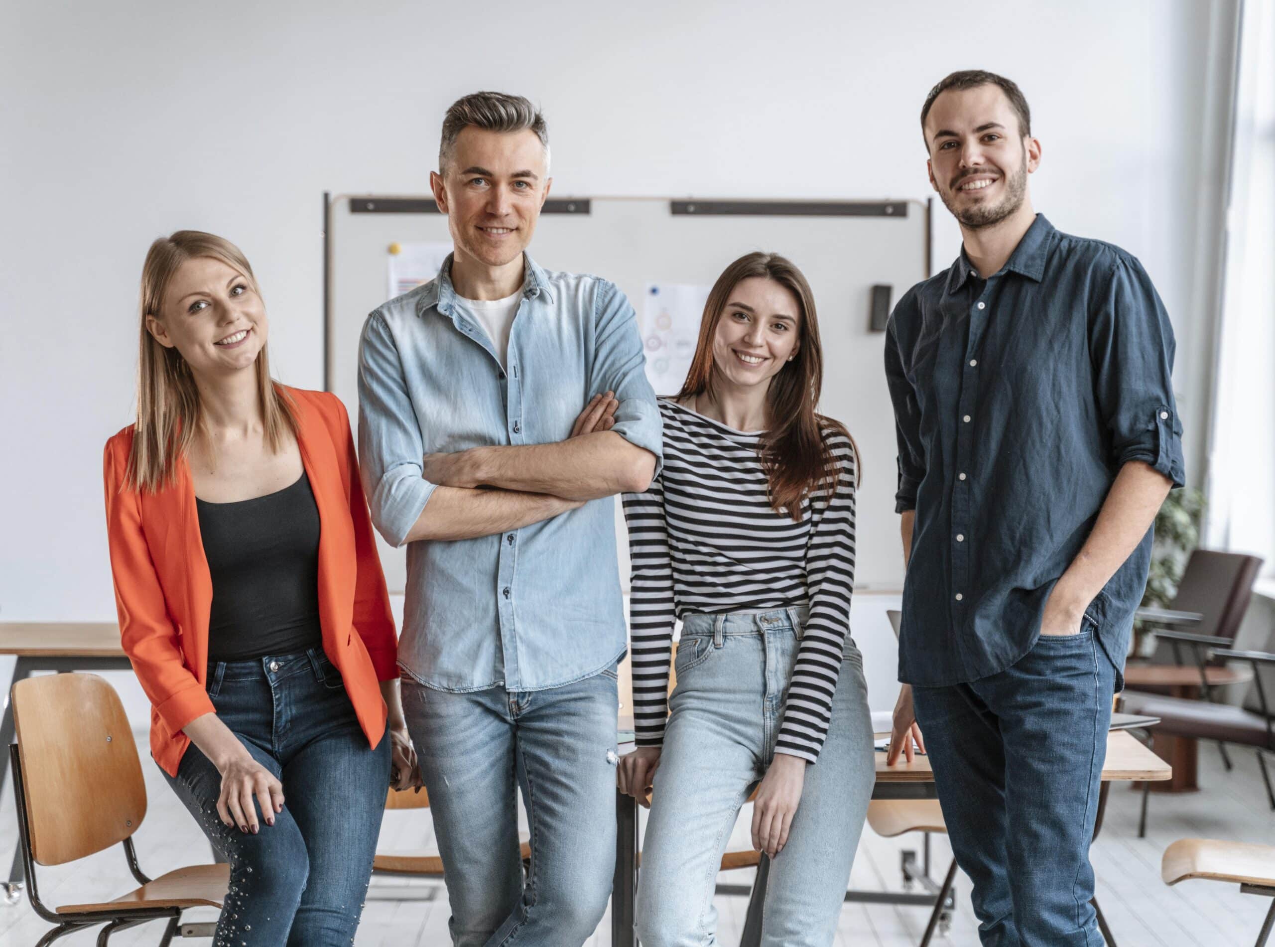 Gruppe junger Mitarbeitender posiert gemeinsam im Büro